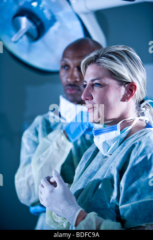 Multi-ethnic doctors in surgical scrubs in hospital room Stock Photo