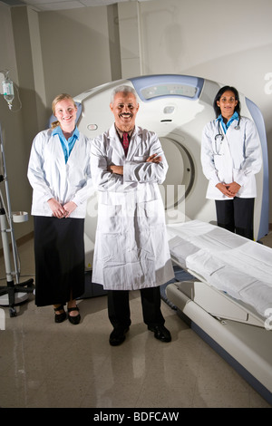 Healthcare workers standing next to CAT scan machine Stock Photo