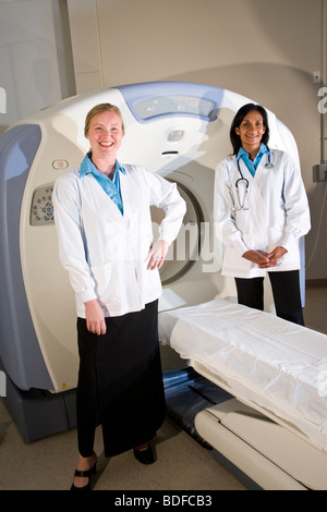 Healthcare workers standing next to CAT scan machine Stock Photo