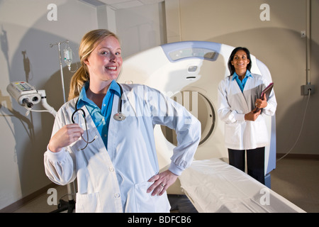 Healthcare workers standing next to CAT scan machine Stock Photo