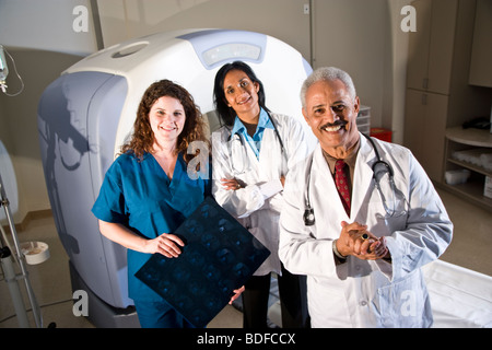 Healthcare workers standing next to CAT scan machine Stock Photo