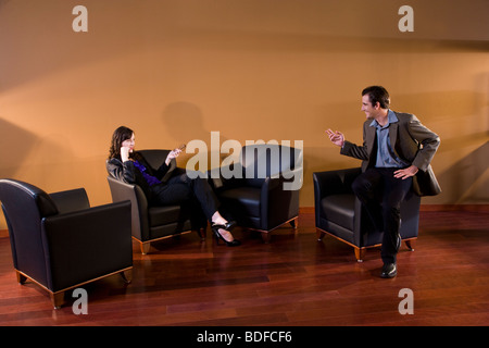 Man and woman having discussion in lounge area Stock Photo