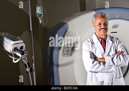 African American radiologist next to CAT scan machine Stock Photo