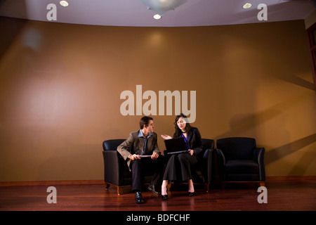 Two business people in lounge area  working together on laptop Stock Photo