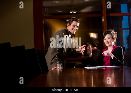 Businessman and businesswoman working together in office board room Stock Photo