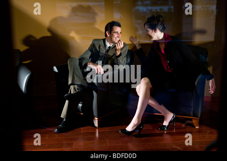 View through glass door of two businesspeople sitting in office lounge Stock Photo