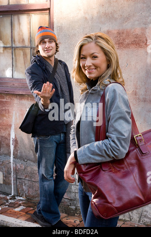 Young man beckoning young woman Stock Photo