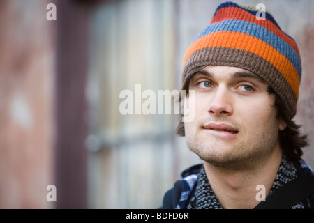 Young stylish man leaning against wall of building Stock Photo