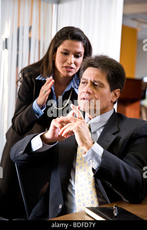 Hispanic businessman and businesswoman talking in office Stock Photo