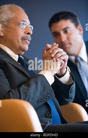 Senior Hispanic businessman with colleague in background Stock Photo