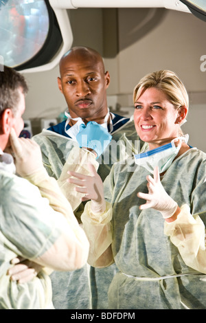 Surgeons conversing in operating room after medical procedure Stock Photo