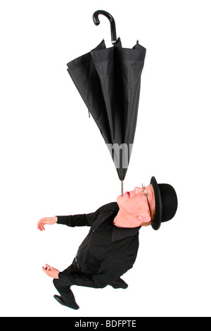 young man with bowler hat balancing an umbrella on his chin Stock Photo