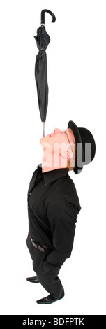 young man with bowler hat balancing an umbrella on his chin Stock Photo