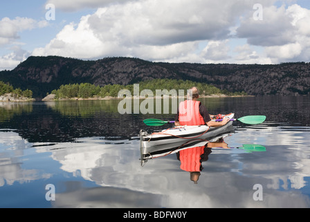 Man kayaking on calm lake Stock Photo