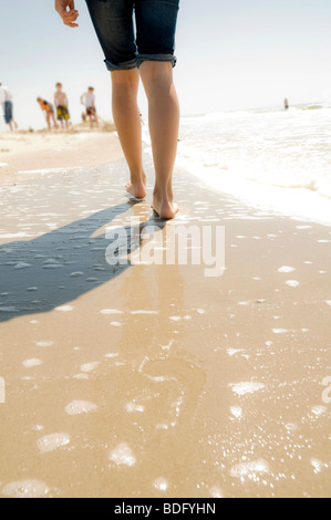 Person strolling along a beach Stock Photo