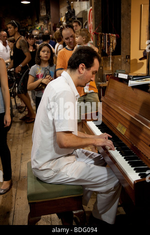 Man playing the piano in Horse Tunnel Market at Camden Market, North London. Camden Lock is a busy hang out for young Londoners. Stock Photo