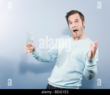 Ice cubes falling into a glass a man's holding