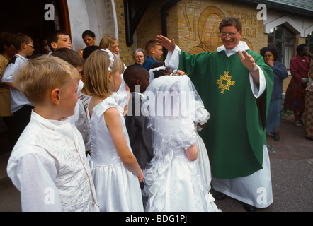 St Joseph's Church Roehampton Children & Priest Arms Outstretched Stock Photo