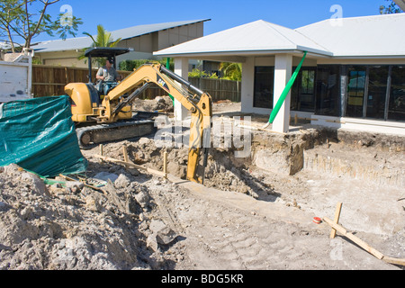 An excavator digging a swimming pool Stock Photo