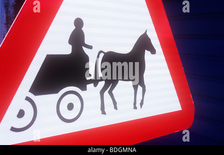 Detail of red white and black triangular roadsign warning that horses or ponies with carriages or traps are in the area Stock Photo