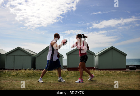 Couple keep fit boxing together on Hove Lawns Brighton Sussex UK Stock Photo