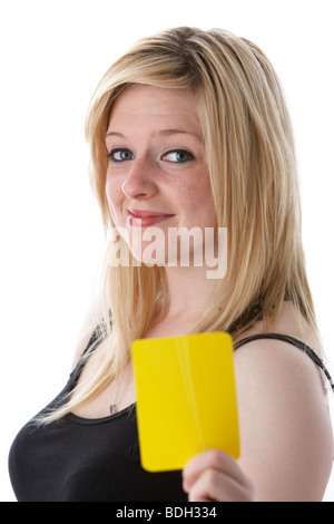 young 20 year old blonde woman holding up yellow soccer football warning card Stock Photo