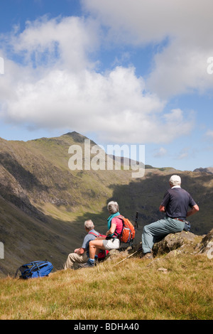 Snowdonia National Park North Wales UK. Three walkers on Yr Aran looking across Cwm Llan towards Mount Snowdon Stock Photo