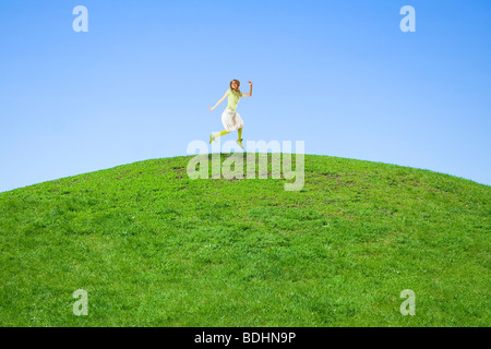 woman jumping on a green meadow Stock Photo