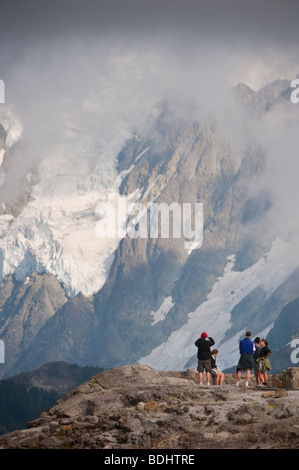 After finishing the Chain Lakes Trail at Mt. Baker, hikers rest at the foot of the glacier on Mt. Shuksan, Washington, USA. Stock Photo