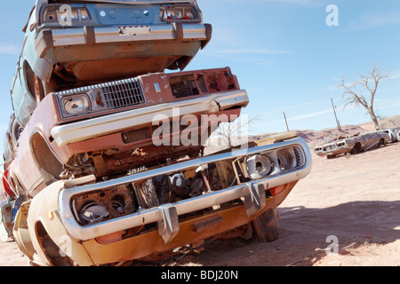 cars in a junk yard against a blue sky, front shot Stock Photo