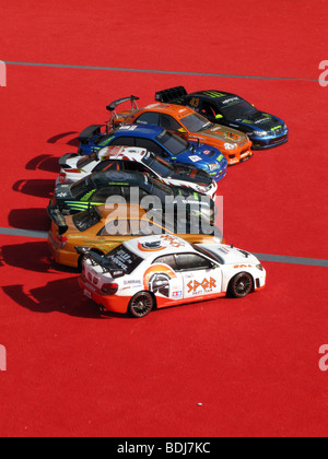 row of toy racing cars on red carpet Stock Photo