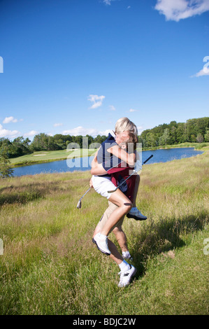 Excited Golfers Hugging and Cheering Stock Photo