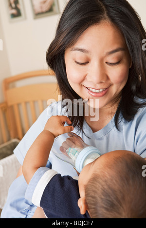 Mother Holding Baby Boy while he is Drinking from Baby Bottle