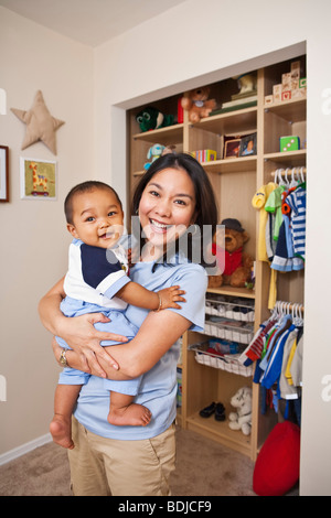 Mother Holding Baby in Nursery Stock Photo