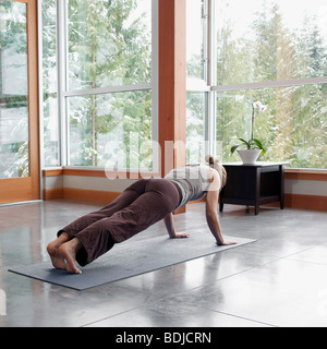 Woman Doing Yoga in Living Room of Large Alpine Home Stock Photo