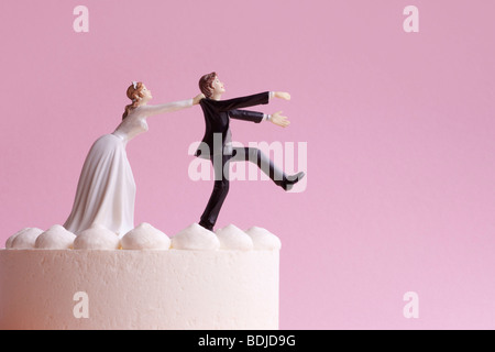 Wedding Cake Figurines, Bride Grabbing Runaway Groom Stock Photo