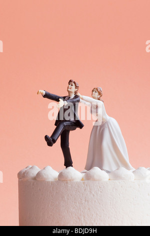 Wedding Cake Figurines, Bride Grabbing Runaway Groom Stock Photo