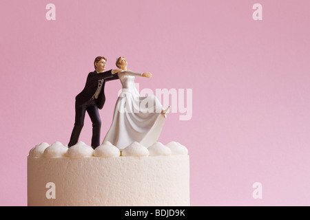 Wedding Cake Figurines, Groom Grabbing Runaway Bride Stock Photo