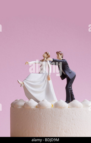 Wedding Cake Figurines, Groom Grabbing Runaway Bride Stock Photo