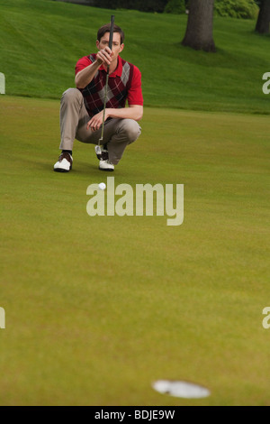 Man Assessing Golf Putt Stock Photo