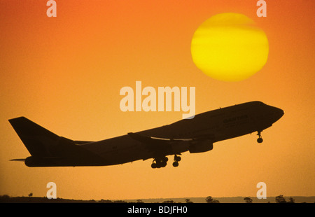 Boeing 747 Jetliner Taking Off, Sunset Silhouette Stock Photo