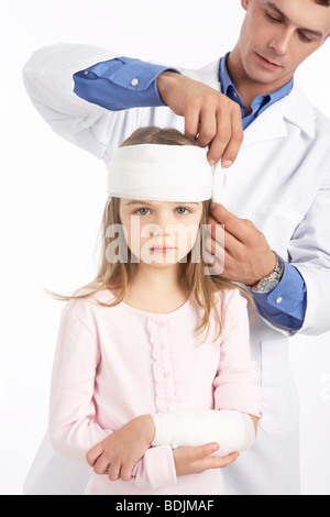 Doctor Wrapping Bandage Around Girl's Head Stock Photo