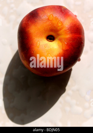 Nectarine fruit ripening in the sun on a windowsill fruit summer Stock Photo
