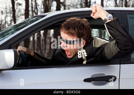 Aggressive driver driving a car and swearing Stock Photo