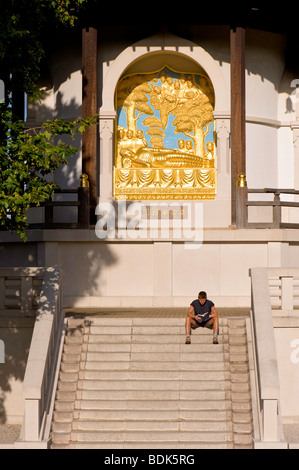 Man relaxing on steps of Peace Pagoda in Battersea Park, SW11, London, United Kingdom Stock Photo