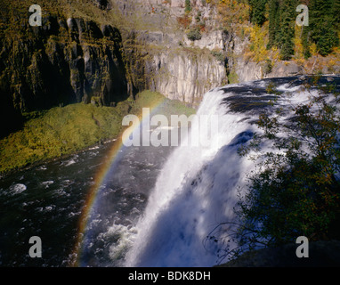 Rainbow forms in the mist from Upper Mesa Falls in the Targhee National Forest of Eastern Idaho Stock Photo