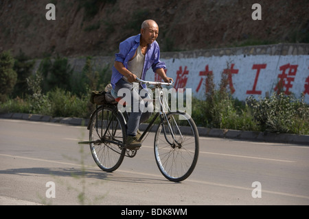 AN TAI BAO MINE, SHANXI PROVINCE, CHINA - AUGUST 2007: A miner cycles home at the end of his shift. Stock Photo