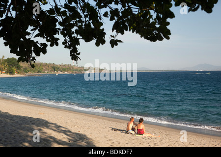 Indonesia, Lombok, Sengiggi, couple alone on near empty beach Stock Photo