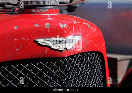 A badge on a vintage Aston Martin Ulster race car, with chipped red paintwork Stock Photo