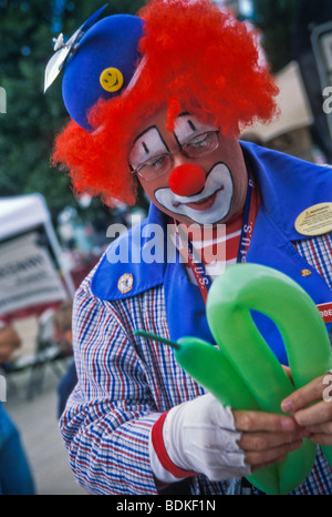 Clown making balloon animals for children and adults Stock Photo - Alamy